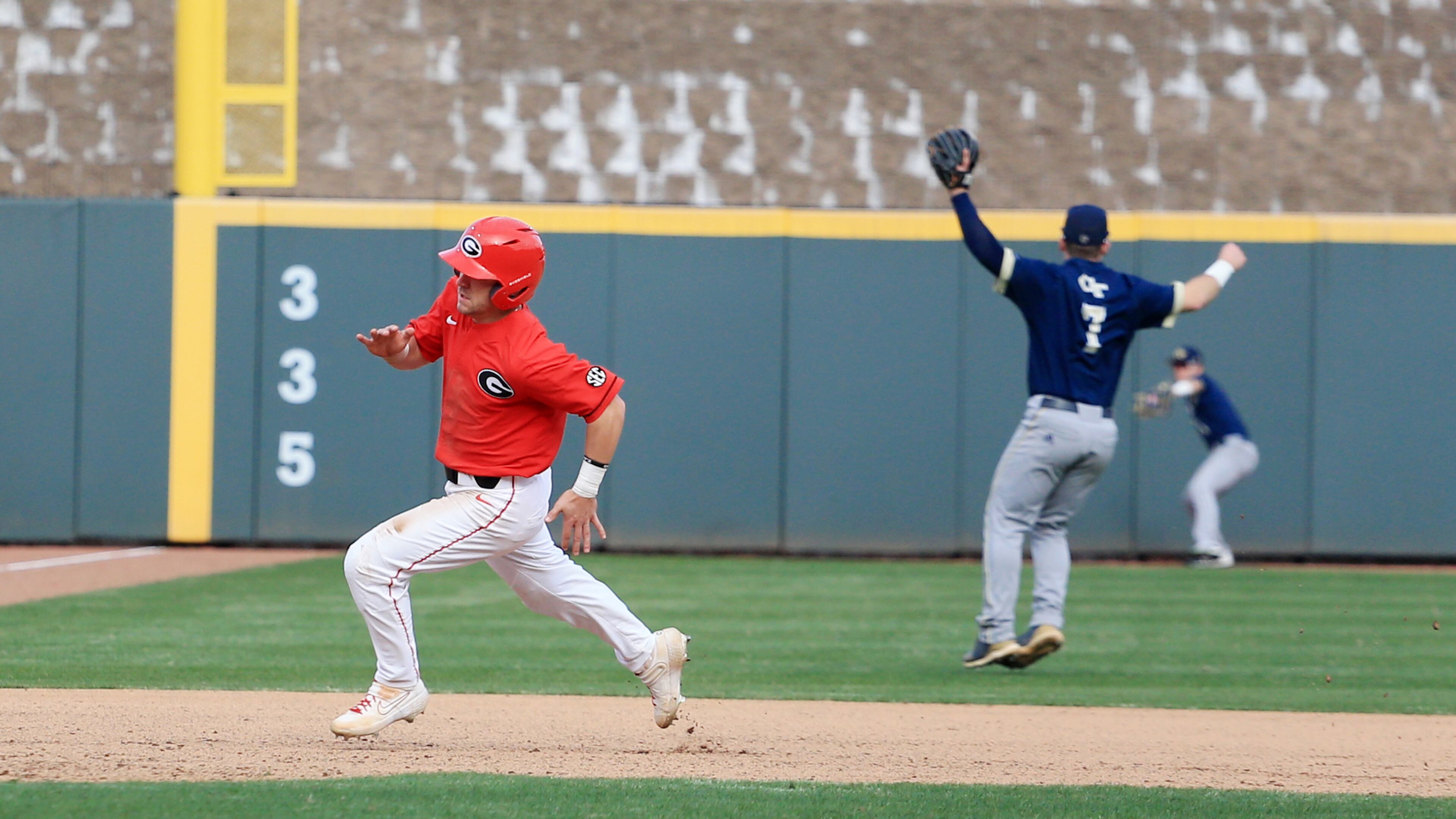 Georgia's Buddy Floyd runs to third base ahead of a Tech cutoff throw by Georgia Tech Sunday, March 1, 2020, at Coolray Field in Lawrenceville. The Bulldogs defeated the Yellow Jackets 9-3.