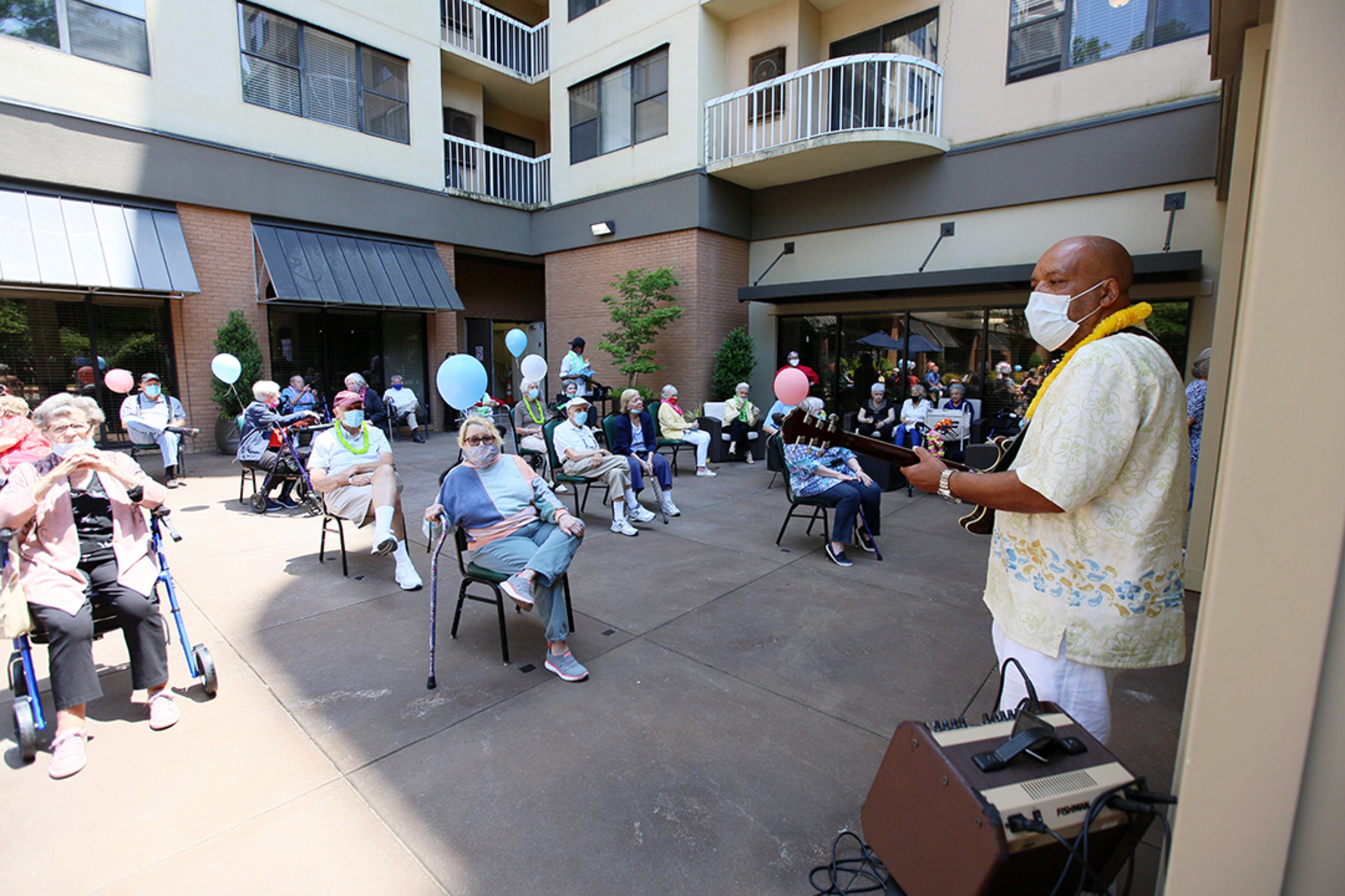 During Peggy Cobb's 105th birthday party, a musician entertains residents outside of the Hammond Glen Retirement Community. Social distancing was a priority for the outdoor celebration on Friday, May 22, 2020. (Photo: Miguel Martinez for The Atlanta Journal-Constitution)