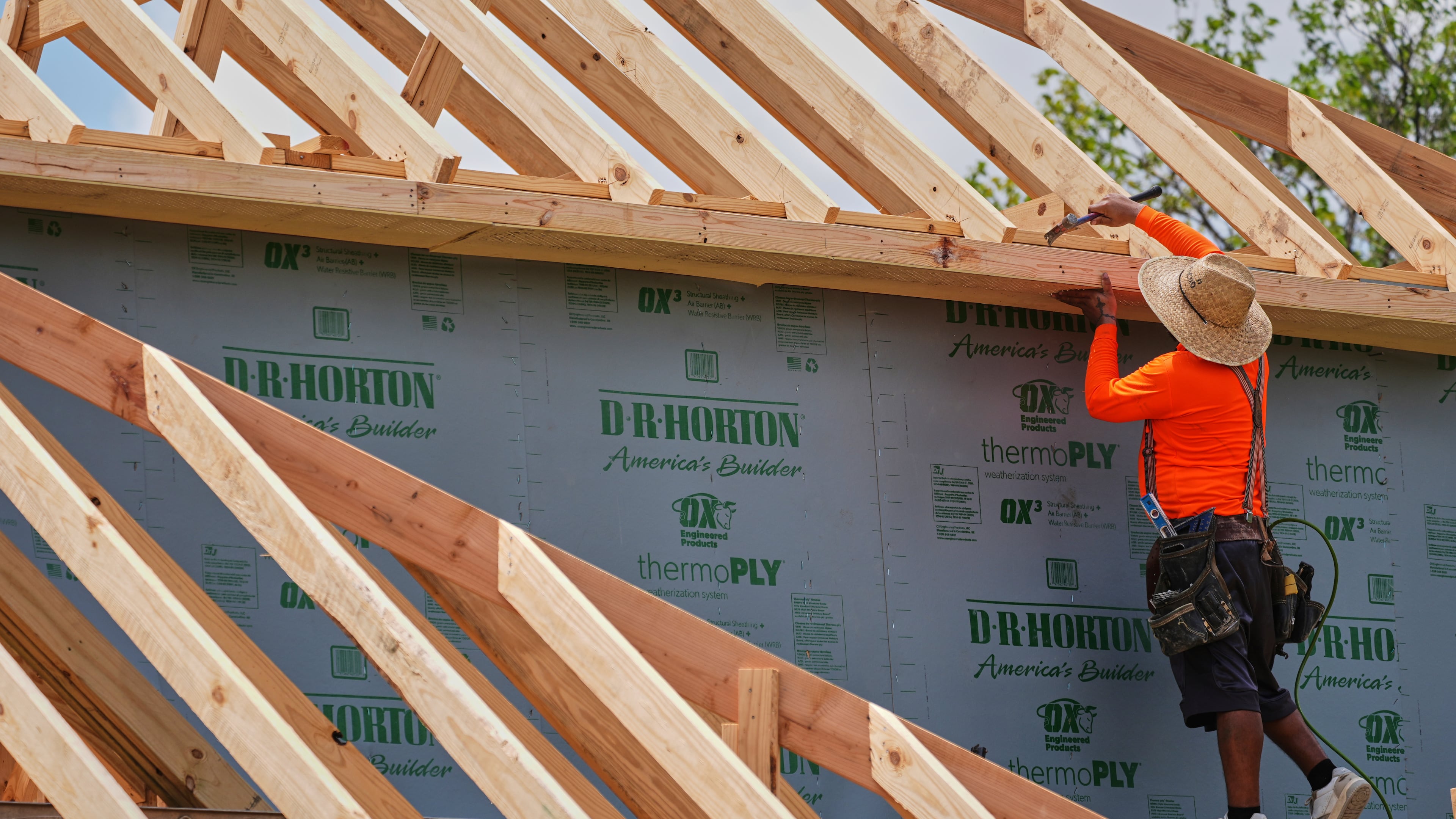 A worker works on the roofing structure of new home under construction, Tuesday, July 15, 2025, in Richardson, Texas. (AP Photo/Tony Gutierrez)