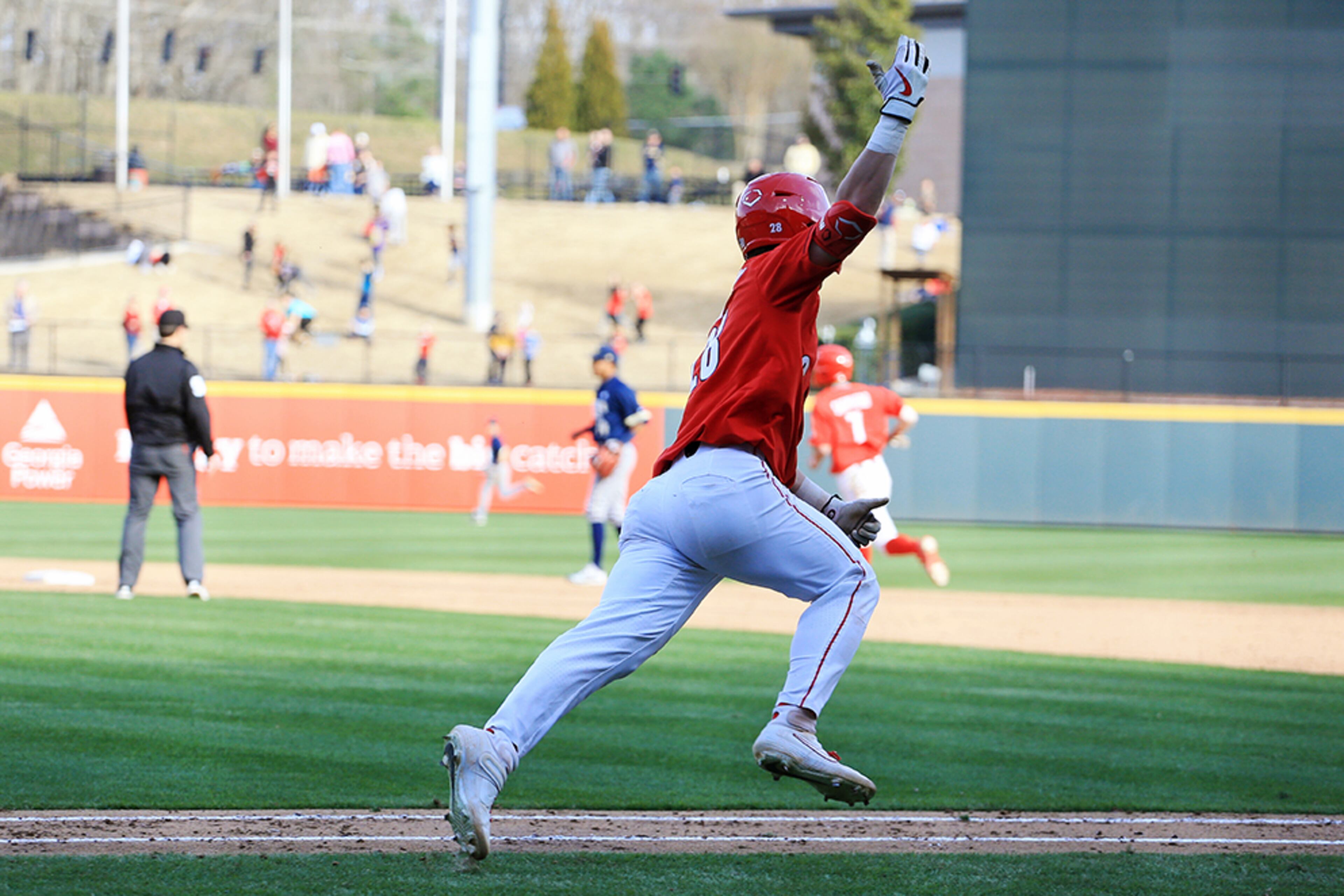 Georgia outfielder Tucker Bradley motions for more cheers from the crowd as he runs toward first Sunday, March 1, 2020, at Coolray Field in Lawrenceville. Georgia won 9-3 over Georgia Tech.